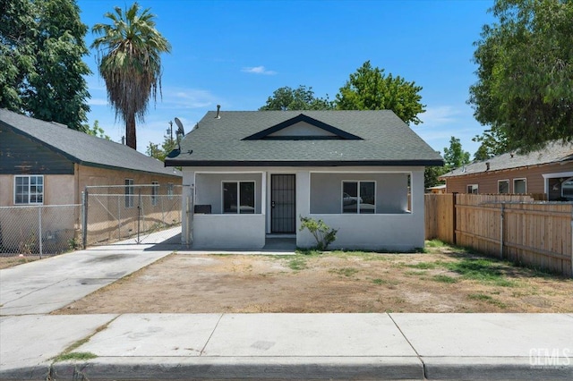 714 R St, Bakersfield, CA 93304 - bungalow-style house with stucco siding, roof with shingles, and a gate