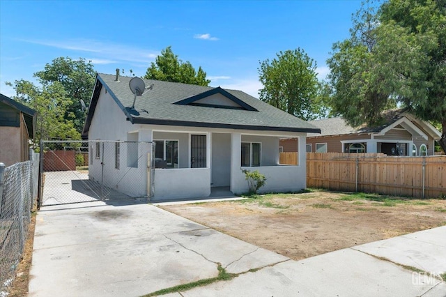 714 R St, Bakersfield, CA 93304 - bungalow-style home with a shingled roof, stucco siding, a gate, and a porch