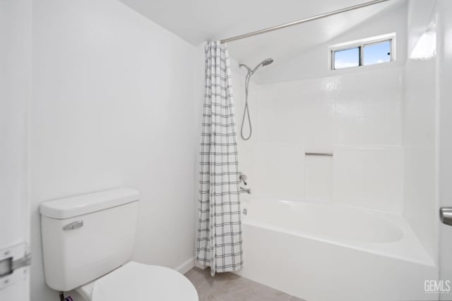 bathroom featuring toilet, lofted ceiling, and shower / tub combo