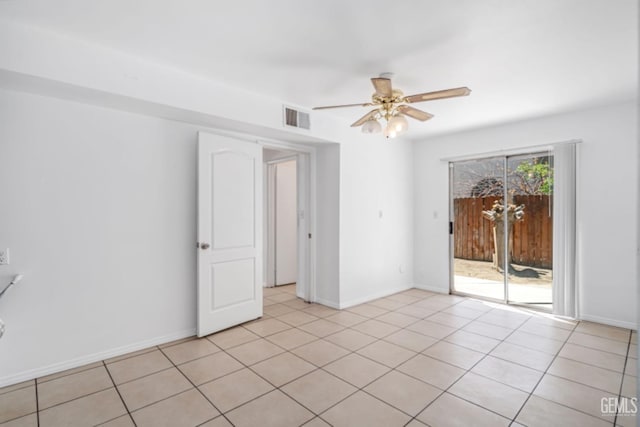 empty room featuring light tile patterned floors, baseboards, a ceiling fan, and visible vents