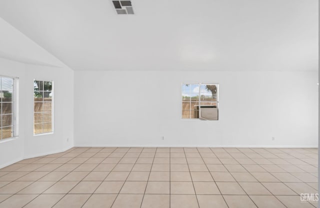 empty room with baseboards, lofted ceiling, and visible vents