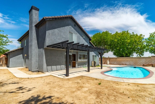rear view of house with a fenced backyard, stucco siding, and a pergola