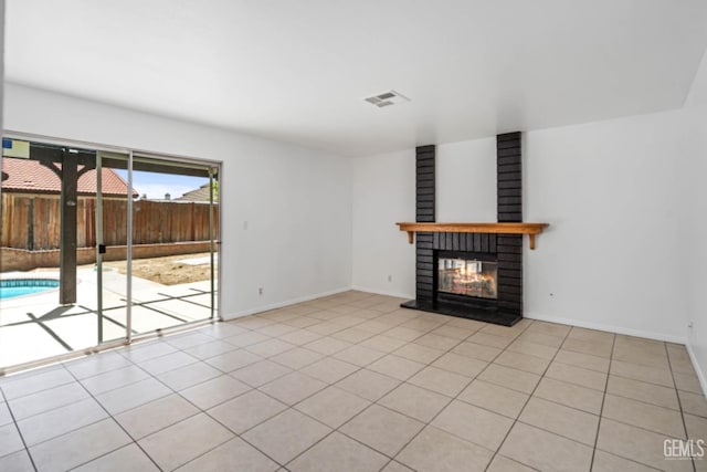 unfurnished living room with visible vents, baseboards, a glass covered fireplace, and light tile patterned floors