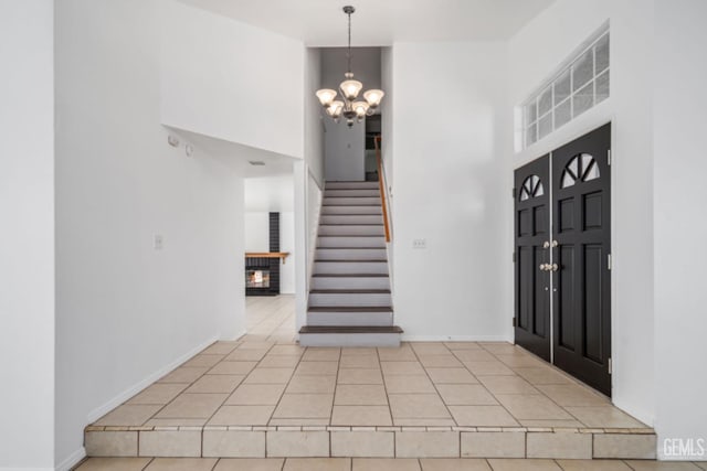 foyer entrance featuring stairs, a high ceiling, and a notable chandelier