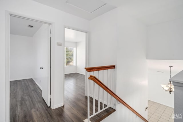 stairs with visible vents and wood finished floors