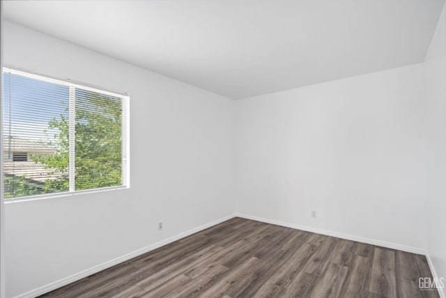 unfurnished room with plenty of natural light, baseboards, and wood finished floors