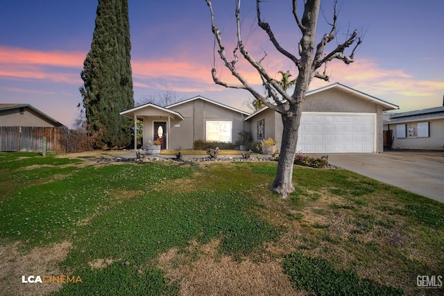 ranch-style home featuring a garage and a lawn