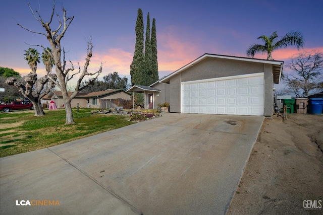 ranch-style house featuring a yard and a garage