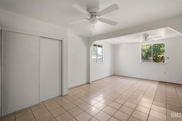 764 E Sutter Ave, Earlimart, CA 93219 - unfurnished bedroom with multiple windows, a closet, light tile patterned floors, and a ceiling fan