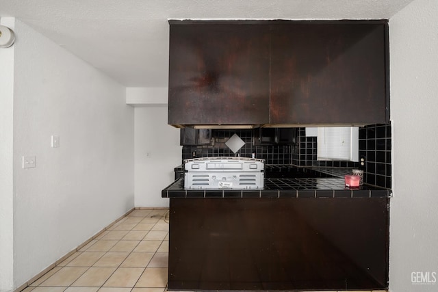 764 E Sutter Ave, Earlimart, CA 93219 - kitchen with tile countertops, decorative backsplash, light tile patterned floors, and dark brown cabinetry
