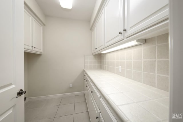 laundry room featuring light tile patterned floors and baseboards