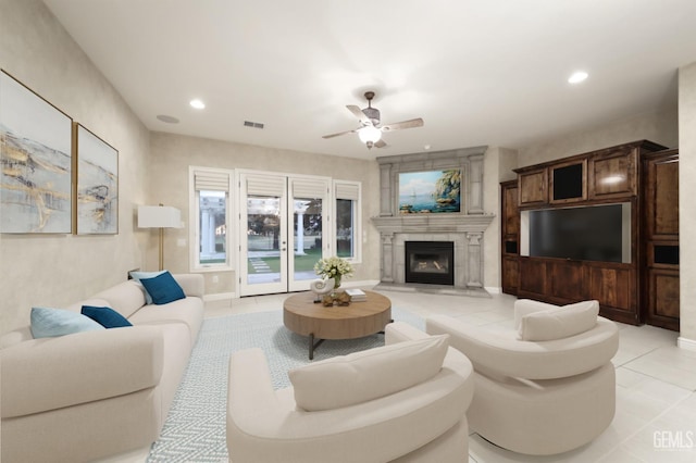 living room with light tile patterned floors, visible vents, ceiling fan, a fireplace, and recessed lighting