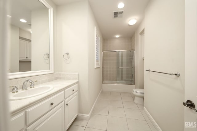 bathroom with tile patterned flooring, toilet, vanity, visible vents, and baseboards