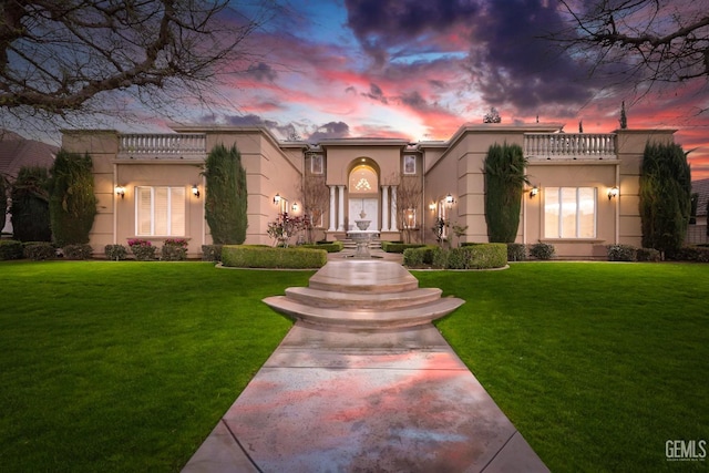 mediterranean / spanish-style home featuring a front lawn and stucco siding