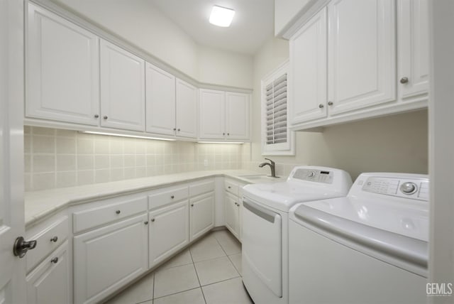 laundry room with light tile patterned floors, separate washer and dryer, a sink, and cabinet space