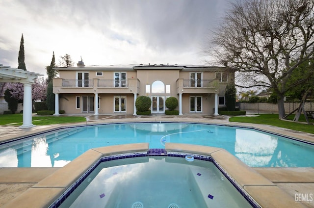 view of pool featuring a pool with connected hot tub, fence, a patio, and french doors