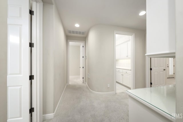 hallway featuring light carpet, recessed lighting, visible vents, and baseboards