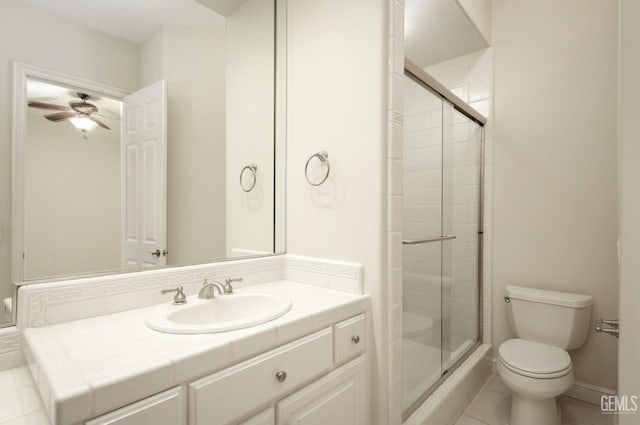 full bath featuring toilet, vanity, baseboards, a shower stall, and tile patterned floors