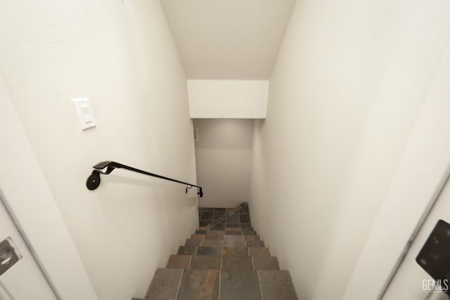 staircase featuring stone finish flooring