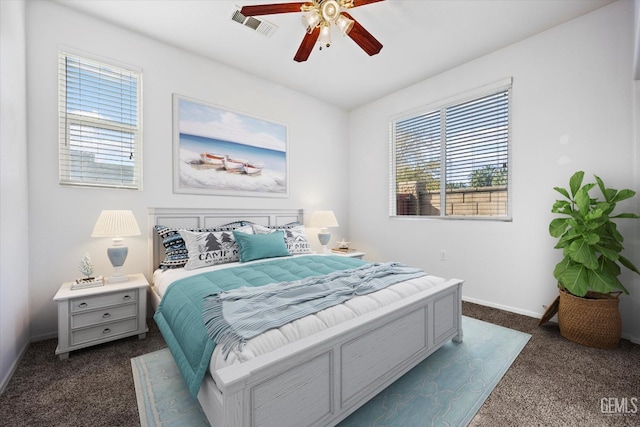 carpeted bedroom with multiple windows and ceiling fan