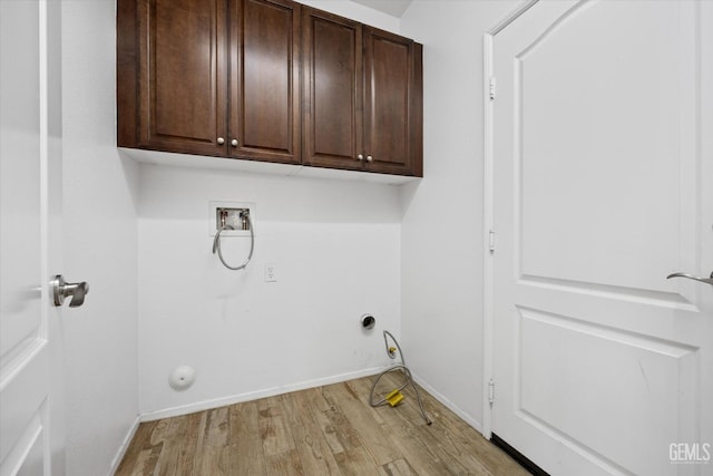 laundry room featuring cabinets, hookup for a washing machine, light hardwood / wood-style flooring, and gas dryer hookup