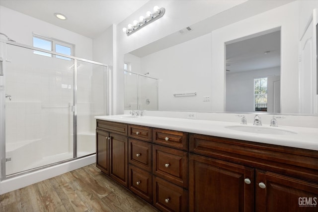 bathroom with hardwood / wood-style floors, vanity, and an enclosed shower