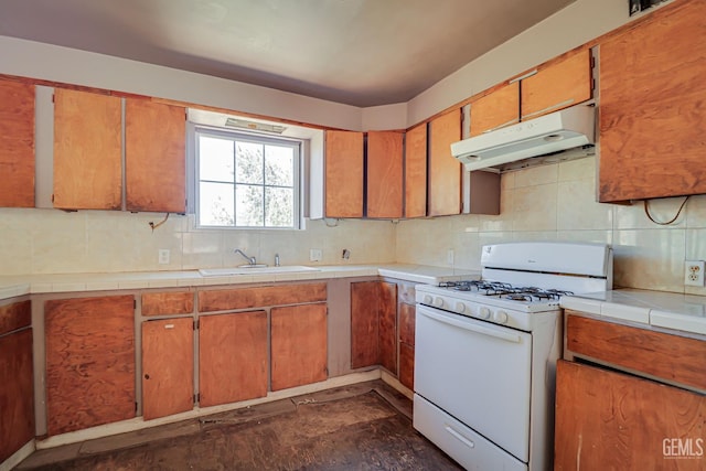 kitchen featuring tasteful backsplash, tile countertops, white gas range, and sink