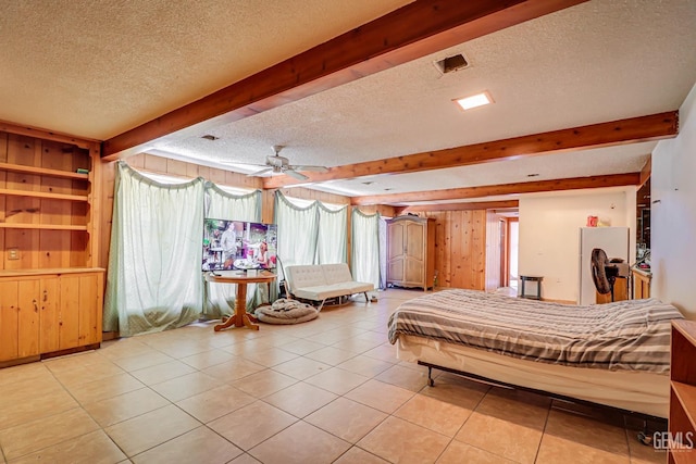 tiled bedroom with ceiling fan, beam ceiling, wooden walls, and a textured ceiling