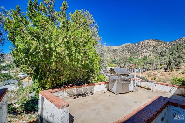 view of patio / terrace featuring a mountain view and a grill