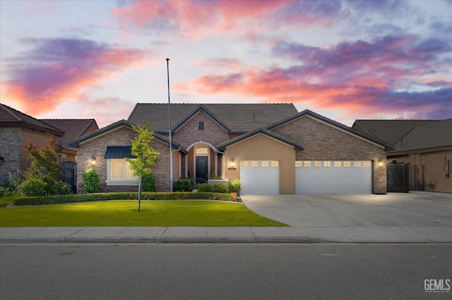 view of front of property featuring a yard, an attached garage, stone siding, and concrete driveway
