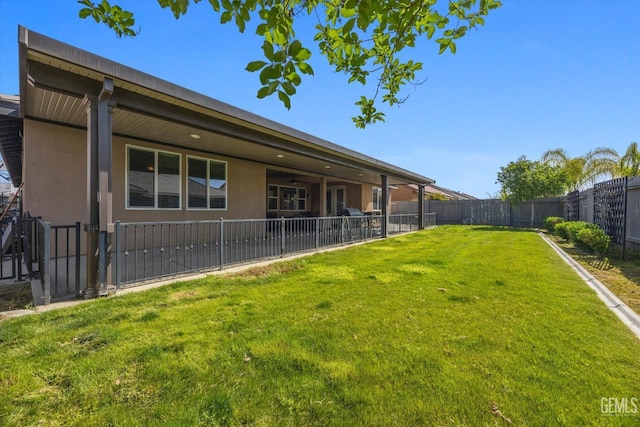 view of yard with ceiling fan and a fenced backyard