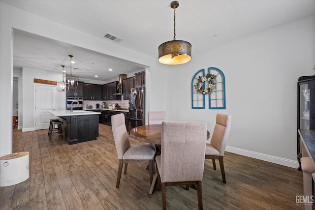 dining room with baseboards, visible vents, an inviting chandelier, and dark wood-type flooring
