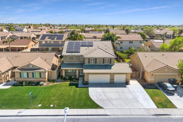 view of front of home with a tile roof, driveway, stucco siding, a front lawn, and a residential view