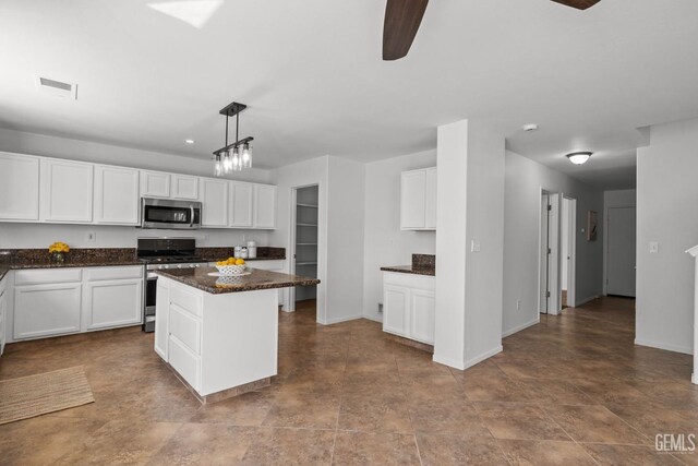 kitchen featuring baseboards, white cabinets, ceiling fan, and stainless steel appliances