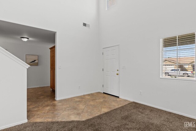 empty room featuring baseboards, visible vents, and carpet floors