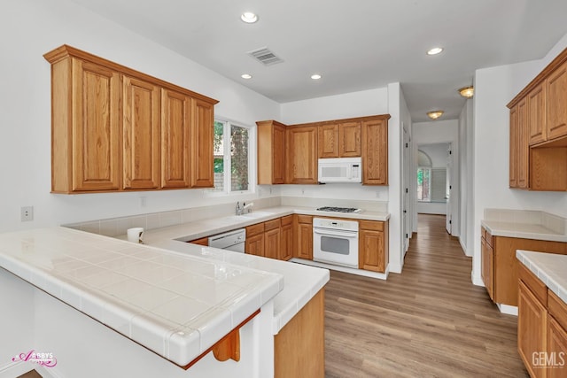 10102 Lace Cascade Ct, Bakersfield, CA 93311 - kitchen featuring white appliances, recessed lighting, light wood-style floors, a peninsula, and light countertops