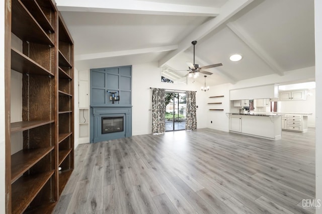 7408 Dos Rios Way, Bakersfield, CA 93309 - unfurnished living room with a glass covered fireplace, ceiling fan, vaulted ceiling with beams, and light wood-style floors