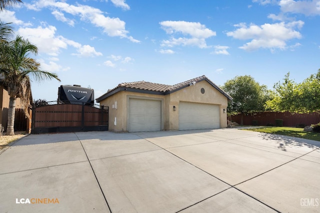 9404 Red Rock Creek Way, Bakersfield, CA 93311 - view of front of home featuring stucco siding, concrete driveway, a gate, and a tiled roof
