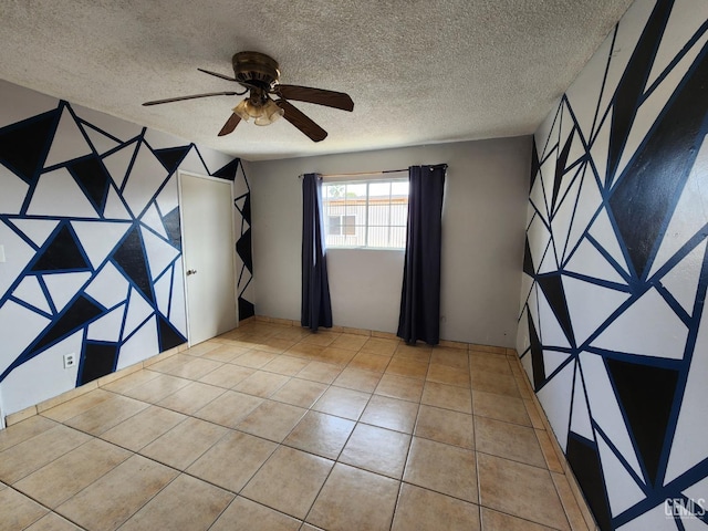 tiled spare room with ceiling fan and a textured ceiling