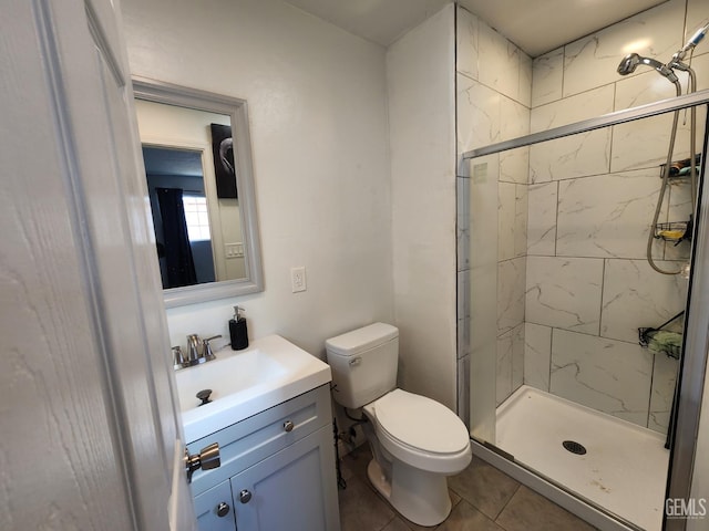 bathroom with tile patterned floors, vanity, toilet, and a shower with door