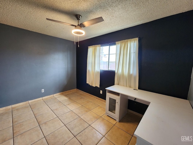 tiled spare room with a textured ceiling and ceiling fan