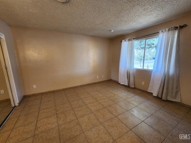 tiled spare room with a textured ceiling