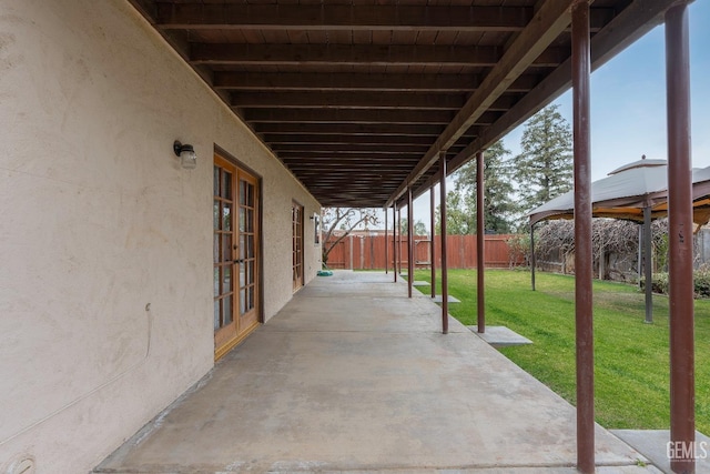 view of patio with french doors, fence, and a gazebo