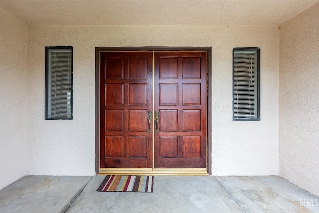 doorway to property featuring visible vents and stucco siding