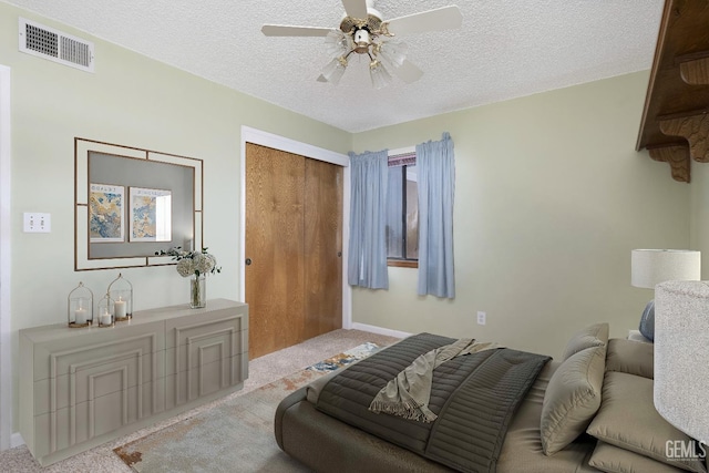 living area with visible vents, a ceiling fan, light carpet, a textured ceiling, and baseboards