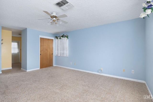 unfurnished bedroom featuring a textured ceiling, carpet flooring, visible vents, baseboards, and a closet