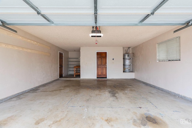 garage featuring water heater, a garage door opener, and baseboards