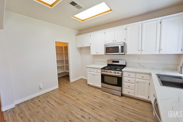 6720 Alderbrook Ln, Bakersfield, CA 93312 - kitchen with stainless steel appliances, light wood-style floors, light stone countertops, and white cabinets