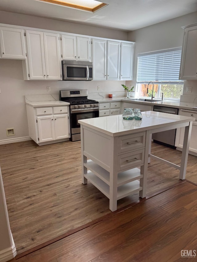 6720 Alderbrook Ln, Bakersfield, CA 93312 - kitchen featuring appliances with stainless steel finishes, light countertops, white cabinetry, wood finished floors, and open shelves