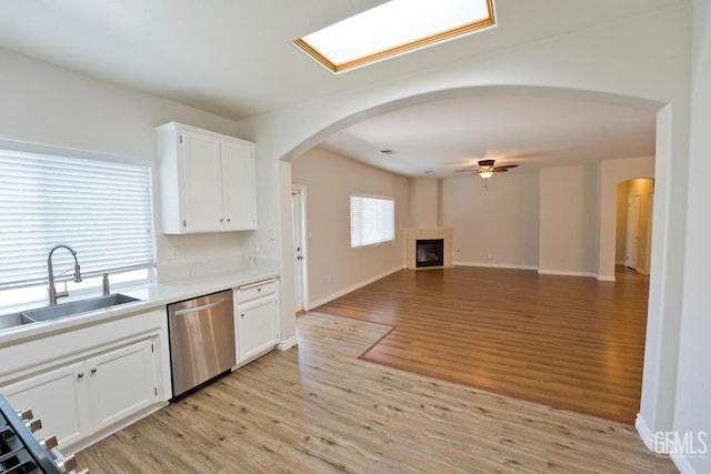 6720 Alderbrook Ln, Bakersfield, CA 93312 - kitchen with dishwasher, a ceiling fan, light wood-style flooring, white cabinetry, and arched walkways